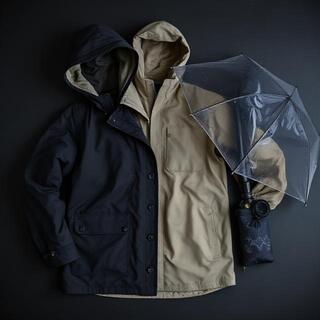Coastal storm layering — hooded coat and windproof umbrella